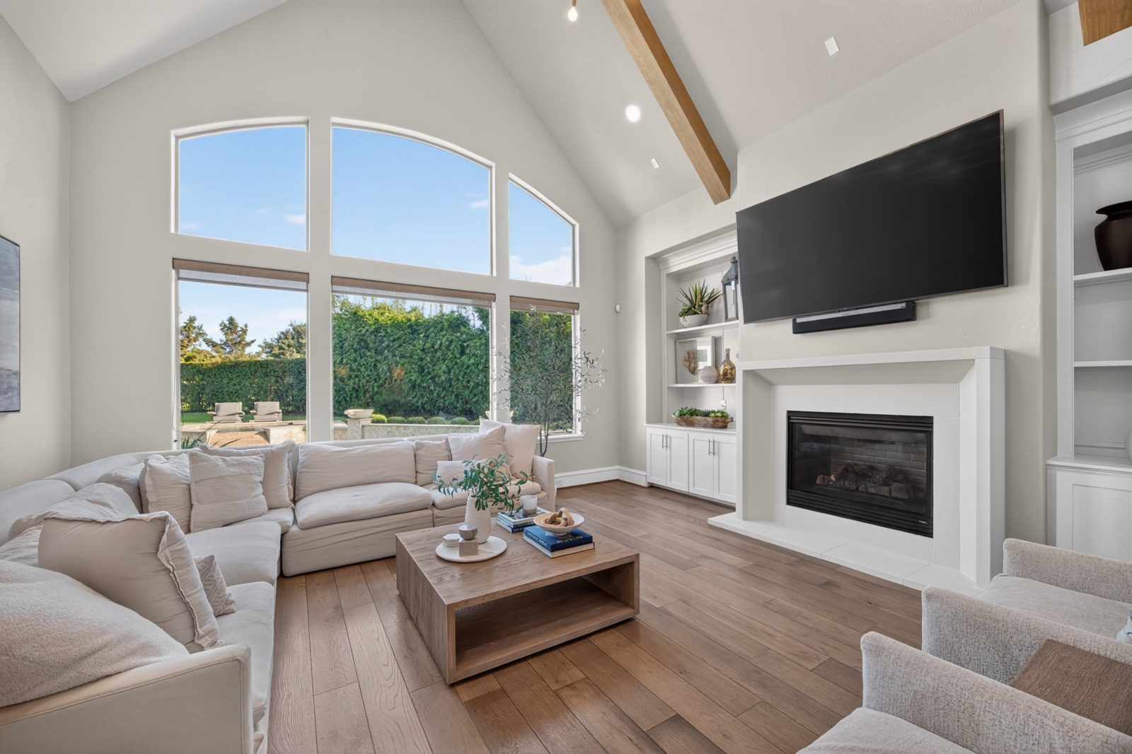 Living room with vaulted ceiling, arched windows and a fireplace